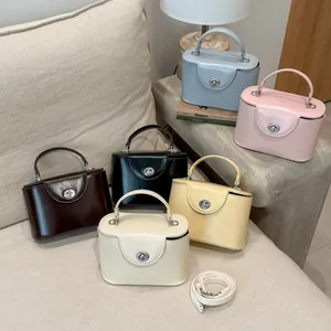 Auswahl von sechs Vintage-Box-Handtaschen in verschiedenen Farben auf einem beigen Sofa