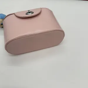 Draufsicht auf eine rosa Box-Tasche mit silbernem Metalldrehverschluss und glatter Textur