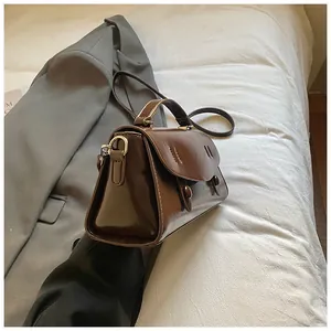 Close-up of vintage brown leather handbag with fine stitching and gold hardware detail