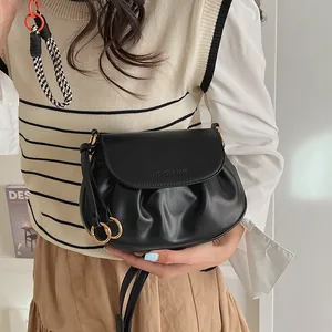Gros plan d'un sac bandoulière en cuir PU plissé noir avec anneau doré élégant