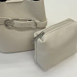 Dettaglio della borsa a secchiello in pelle martellata bianco crema e pochette set