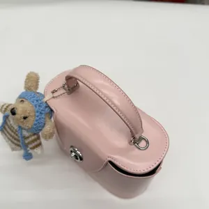 Detailansicht der rosa Ledertasche mit silbernem Drehverschluss und Plüschbär-Anhänger