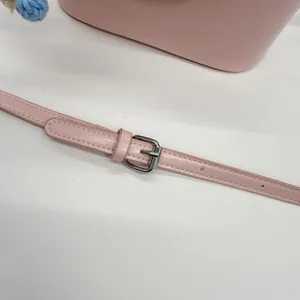 Detailansicht des rosa Lederriemens mit Silberschnalle und verstellbaren Löchern der Tasche