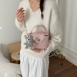 Detailansicht der rosa Box-Tasche mit Silberverschluss und süßem Strickbären-Anhänger