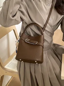 Borsa a secchiello in pelle marrone scuro con manico, tracolla e ciondolo a orsetto