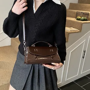 Deep brown glossy leather Cambridge bag with vintage buttons and adjustable strap