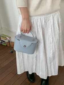 Elegante hellblaue Koffer-Tasche mit silbernem Drehverschluss und Tragegriff