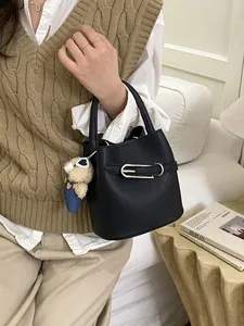 Borsa a secchiello minimalista in pelle nera con fibbia in metallo e ciondolo a orsetto