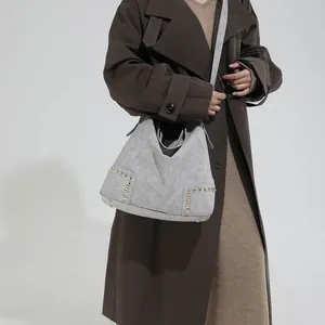 Gray faux suede tote bag with golden rivets and spacious minimalist shoulder design