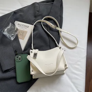 Macro detail of creamy white lychee grain leather handbag with silver metal hardware accents