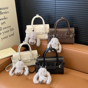 Detail of four retro mini leather handbags in various colors with cute plush rabbit charms