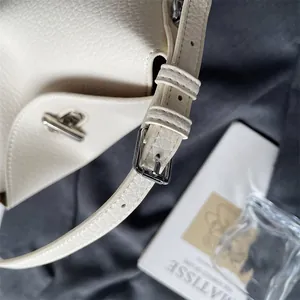 Détail du sac à main en cuir grainé crème avec boucle argentée et coutures de précision