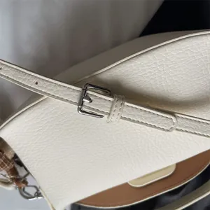 Gros plan sur le sac à main blanc cassé en cuir grainé avec boucle en métal argenté
