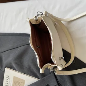 Top view of the small crossbody bag interior with brown lining and a zippered pocket