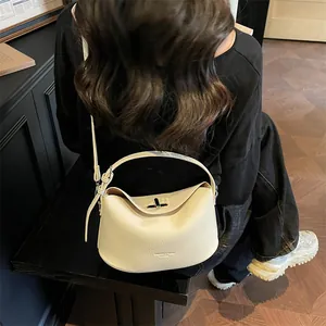 Vue détaillée d'un sac à bandoulière en cuir grainé beige avec fermoir en métal