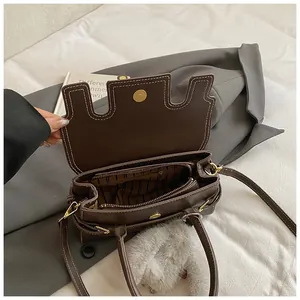 Detail of vintage brown handbag interior with magnetic gold clasp and striped lining