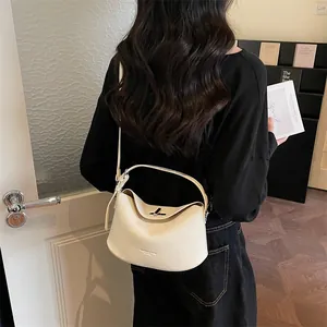 Détail du sac à main en cuir grainé avec fermoir rotatif en métal et bandoulière