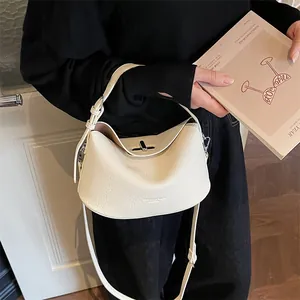 Détail du sac blanc cassé à motif litchi avec fermoir pivotant en métal argenté et anse