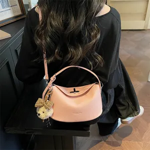 Détail du sac en cuir rose avec boucle en métal et charmant petit ours en peluche