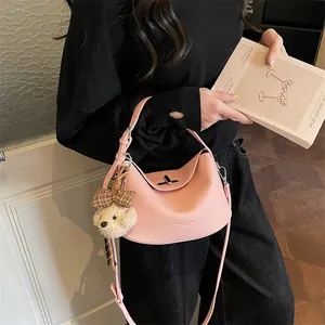 Détail du sac en cuir rose avec fermoir argenté et breloque ours en peluche douce
