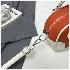Detail von orange-weißen Ledernähten mit silbernem Metallreißverschluss an Bowlingtasche
