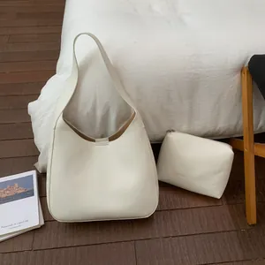 Dettaglio della borsa hobo bianca vintage con pochette interna su sfondo minimalista