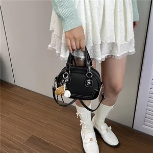 Detail der schwarzen Bowling-Tasche mit weißen Kontrastnähten und Sportanhänger-Dekor