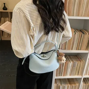 Sac à main bleu clair avec motif litchi, fermoir argenté et breloque ours mignonne