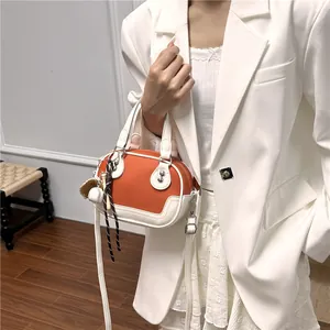 Detail der orange-weißen Bowling-Tasche mit Lederstruktur und Baseball-Anhänger