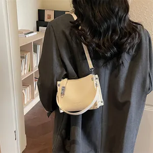 Detail of cream lychee leather shoulder bag with FASHION & BAGS inscription and metal buckle