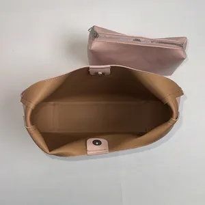 Vista dall'alto della borsa tote rosa con fodera marrone e pochette coordinata con zip