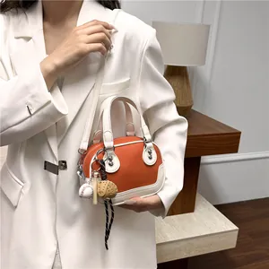 Detailaufnahme der orange-weißen PU-Lederhandtasche mit originellem Baseball-Themenanhänger