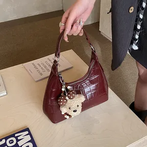 Détail du sac hobo bordeaux gaufré crocodile avec un joli pendentif ours en peluche