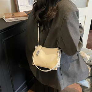 Close-up of cream crossbody bag with lychee texture leather and silver hardware details