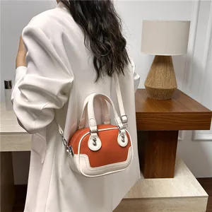 Detail einer Kontrastnaht Mini-Boston-Tasche aus orangefarbenem Leder mit Nieten