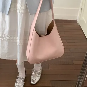 Grande borsa hobo rosa in ecopelle abbinata a un outfit casual ed elegante