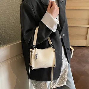 Close-up of the beige textured leather handbag featuring Fashion & Bags logo lettering