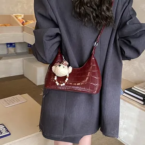 Détail du sac hobo bordeaux avec motif crocodile et joli charm d'ours en peluche