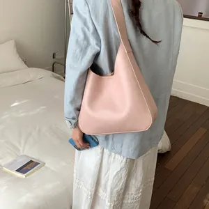 Vista laterale dettagliata della borsa tote in pelle rosa con blazer blu e vestito