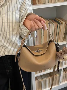 Sac hobo élégant en cuir litchi camel avec fermoir rotatif argenté et ours