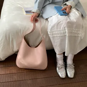 Dettaglio della borsa hobo oversize in pelle rosa cipria per il pendolarismo quotidiano