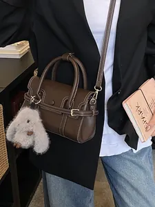 Vintage dark brown crossbody handbag with white stitching and a cute rabbit charm