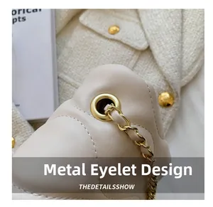 Detail of cream leather bag showing gold hardware perforation and woven chain strap
