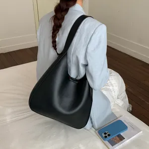 Dettaglio della borsa hobo retrò nera in pelle PU opaca portata a spalla sul modello