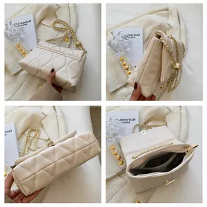 Macro shot showing wavy quilting texture and golden chain on white shoulder bag