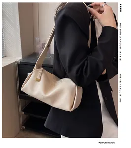 Detail of soft cream leather crossbody bag featuring stylish folds and wide strap