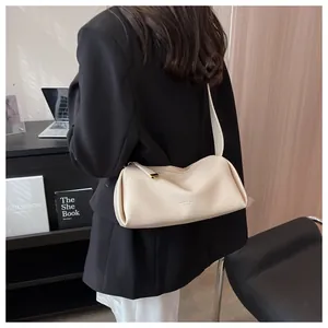 Detailed close-up of soft lychee pattern texture and wide strap on white crossbody bag