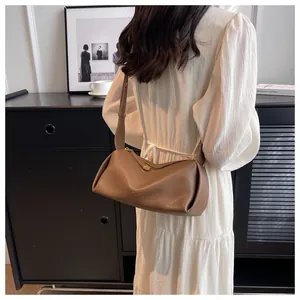 Detailed view of brown lychee grain leather crossbody bag with adjustable wide strap