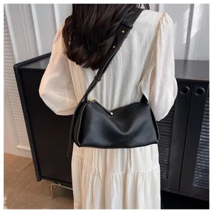 Rear view of a black lychee texture crossbody bag with wide strap and gold hardware