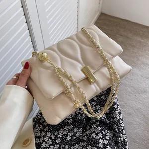 Elegant cream quilted chain bag with gold metal ball detail and square turn-lock closure